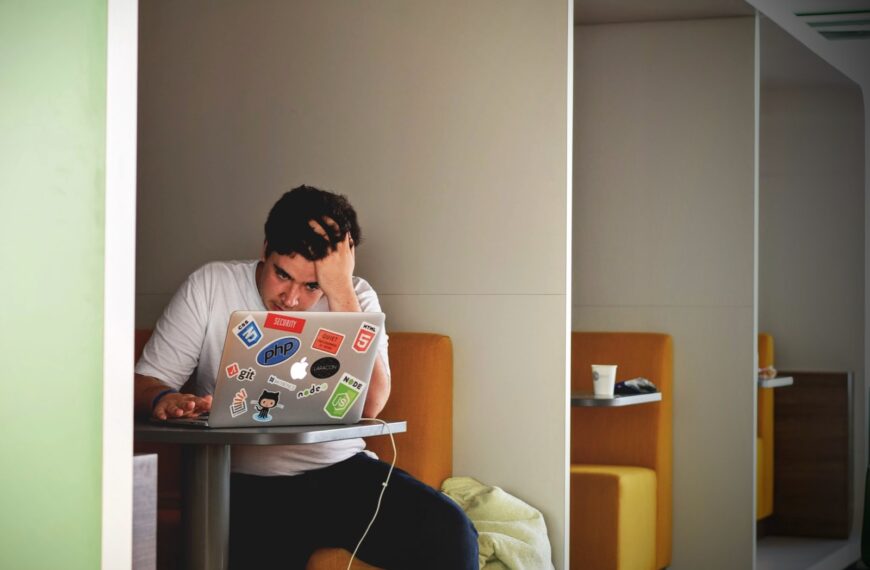 man wearing white top using MacBook