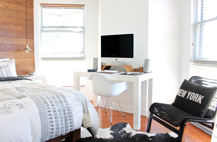 white wooden desk near bed inside the room