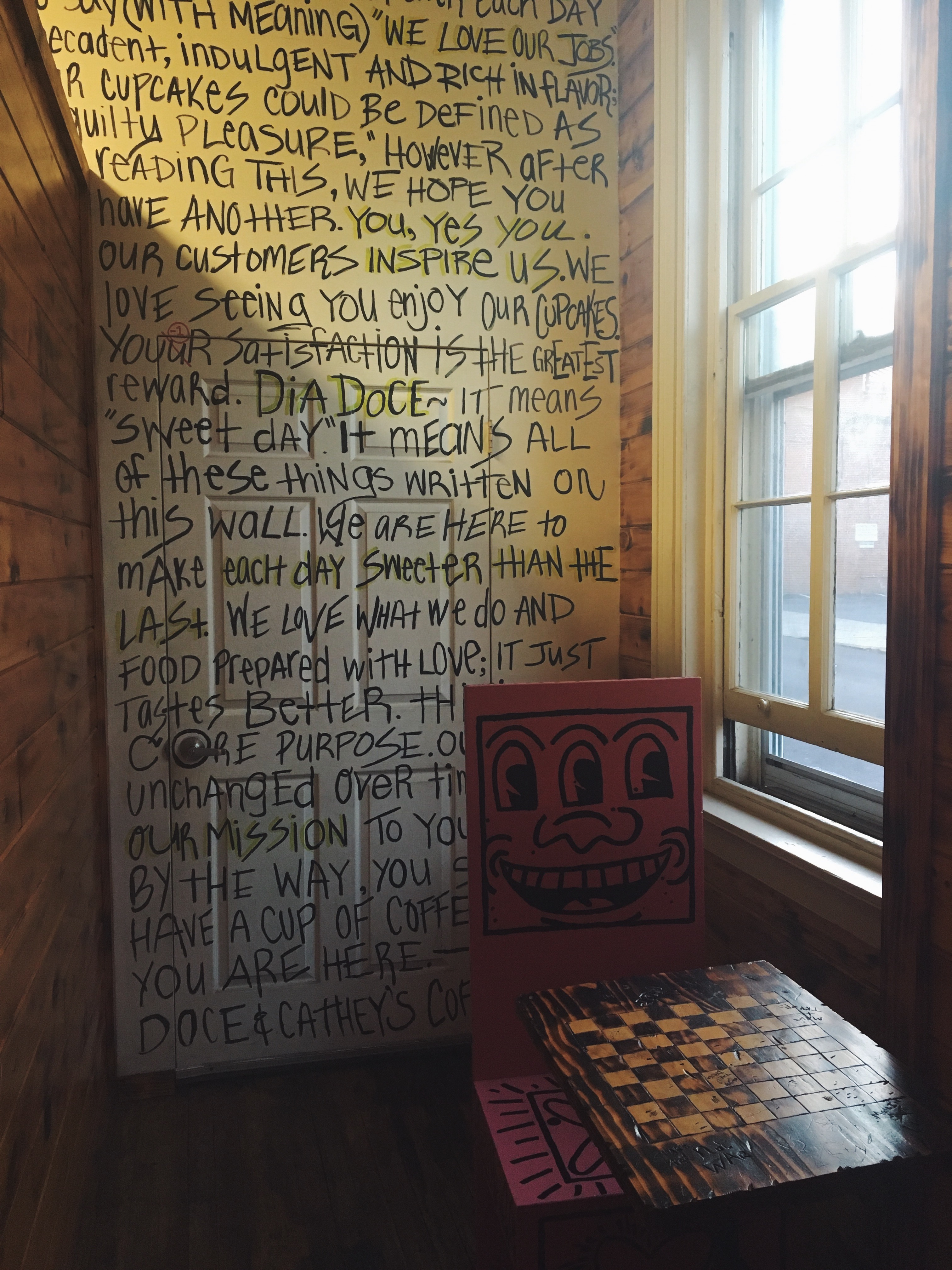 West Chester study spots: a smiling chair sits in front of a word-filled wall inside the coffee and cupcake shop Dia Doce, located on High Street