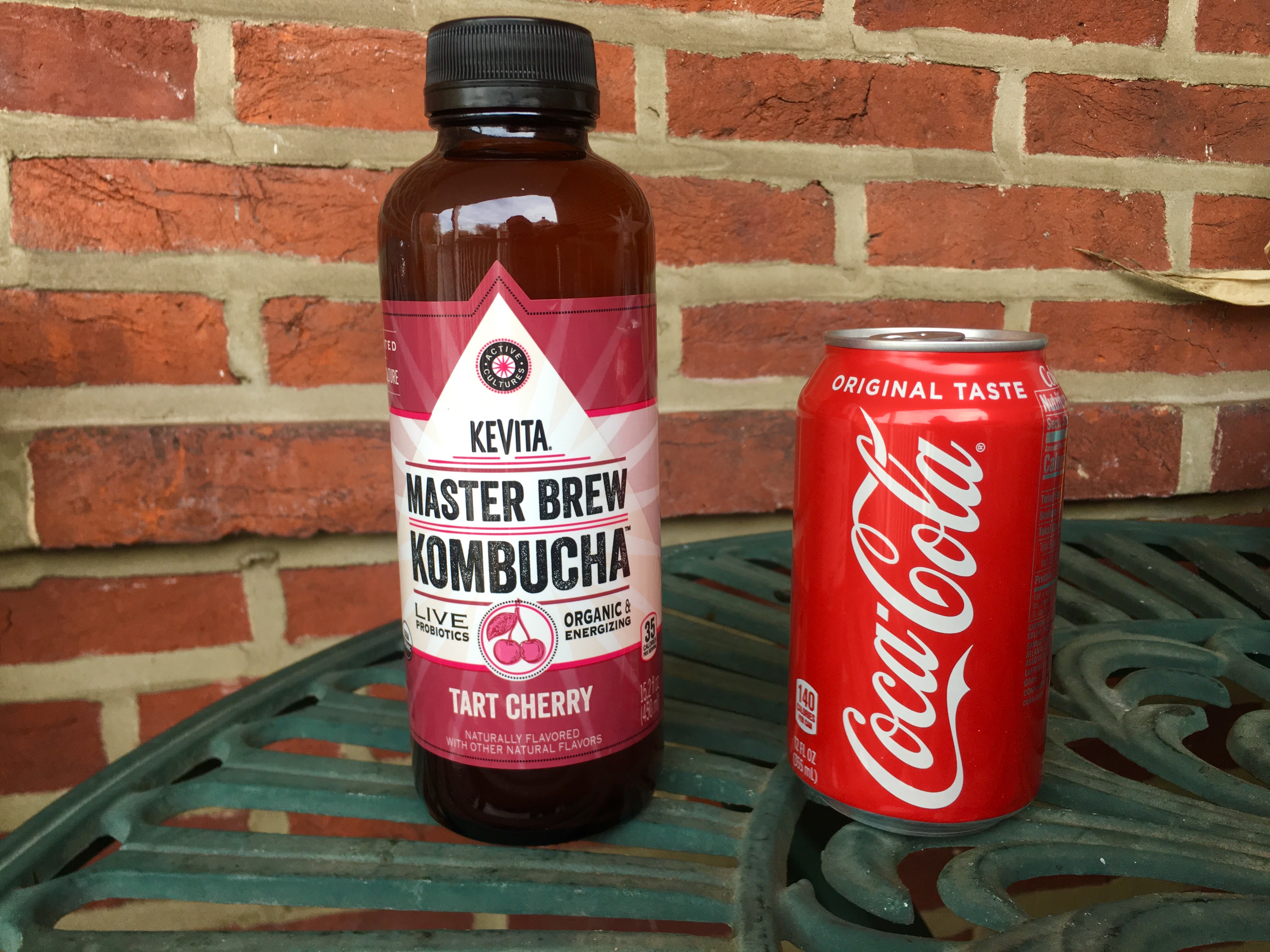 Kombucha bottle next to a can of coke 